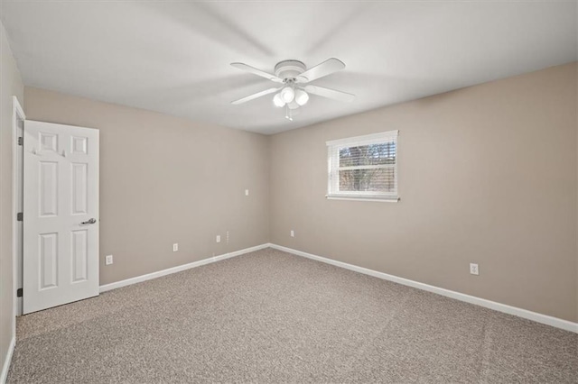 carpeted spare room with baseboards and a ceiling fan