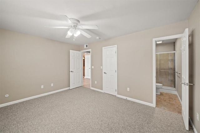 unfurnished bedroom featuring carpet floors, connected bathroom, baseboards, and a ceiling fan