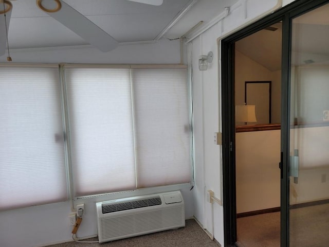 interior space with an AC wall unit and carpet flooring