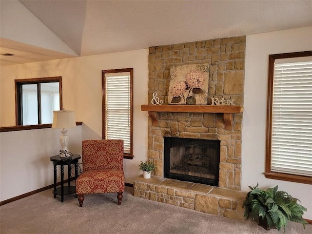 sitting room with lofted ceiling, a fireplace, a wealth of natural light, and carpet floors