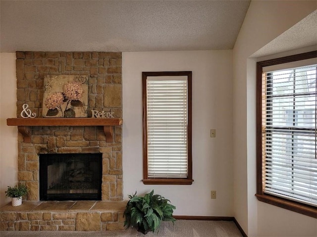 interior space featuring a stone fireplace and a textured ceiling