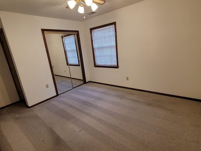 unfurnished bedroom featuring light colored carpet, a closet, and ceiling fan