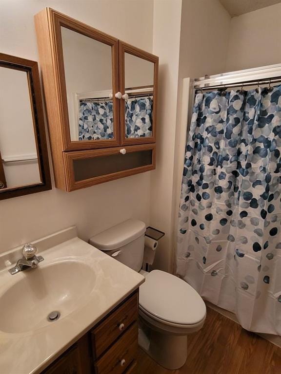 bathroom with hardwood / wood-style flooring, vanity, and toilet