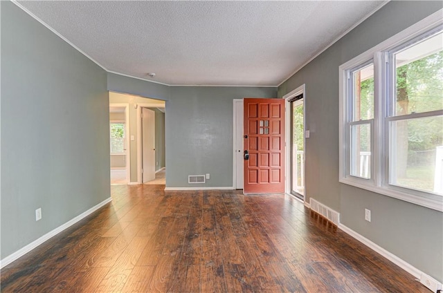 foyer featuring crown molding, plenty of natural light, dark hardwood / wood-style floors, and a textured ceiling