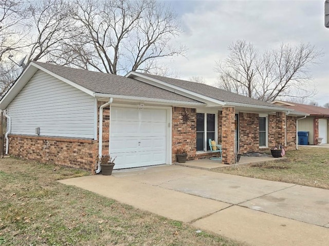 view of front of home featuring a garage, brick siding, driveway, and a front lawn