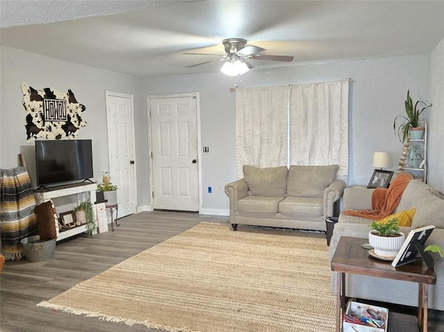 living room featuring wood finished floors, a ceiling fan, and baseboards