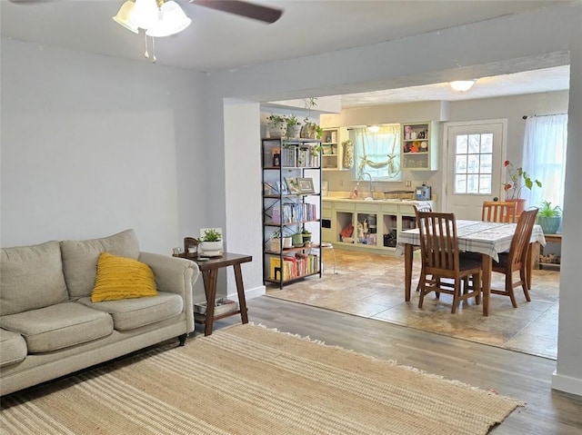 living area with ceiling fan and light wood-style flooring