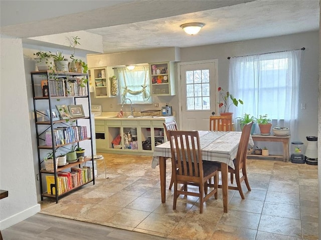 dining area featuring a textured ceiling and baseboards