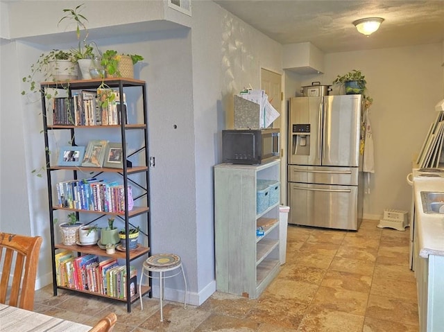 kitchen featuring stainless steel fridge, visible vents, black microwave, and baseboards