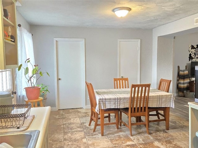 dining room with stone finish flooring and baseboards