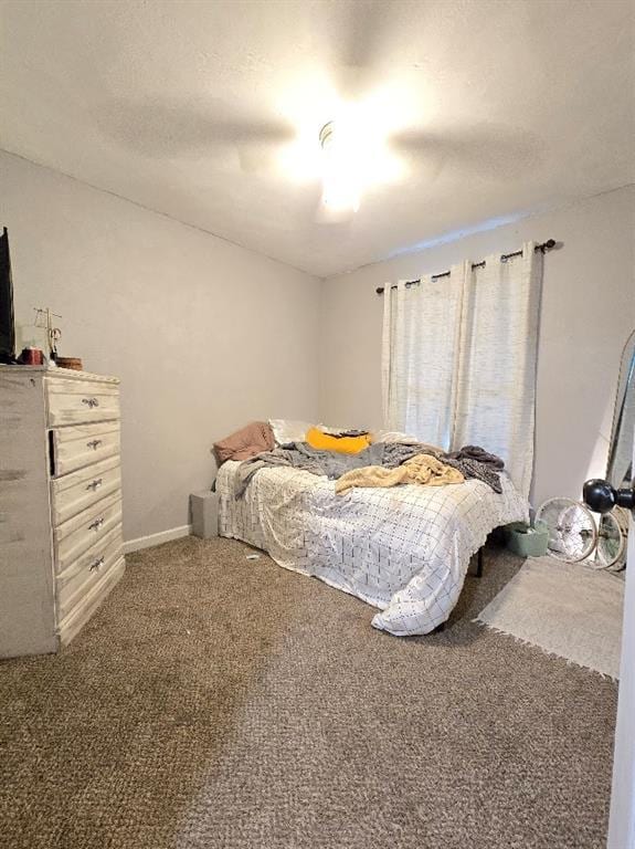 bedroom with baseboards, carpet, a ceiling fan, and a textured ceiling