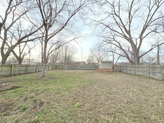 view of yard featuring an outbuilding, a fenced backyard, and a storage unit