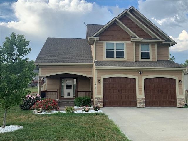 craftsman-style home with a garage, a front lawn, and covered porch