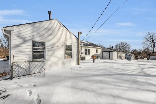 snow covered property with fence