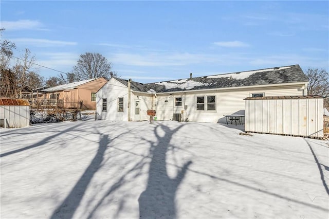 snow covered house with an outbuilding and a shed