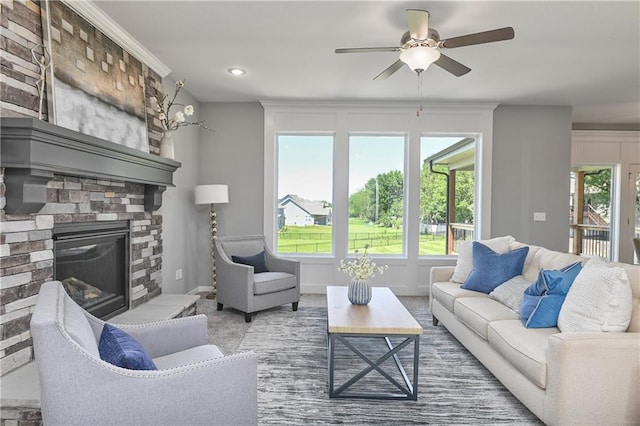 living room with ceiling fan, a large fireplace, plenty of natural light, and carpet flooring