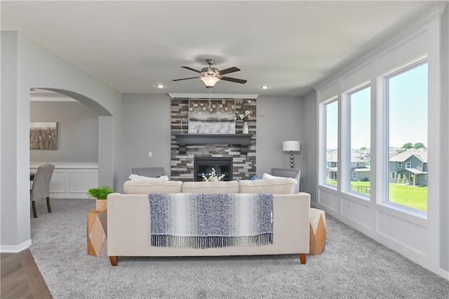 living room with a fireplace and ceiling fan