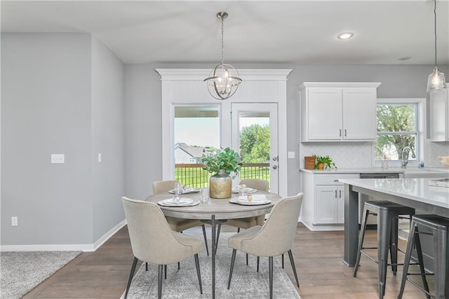 dining space featuring wood-type flooring and a notable chandelier