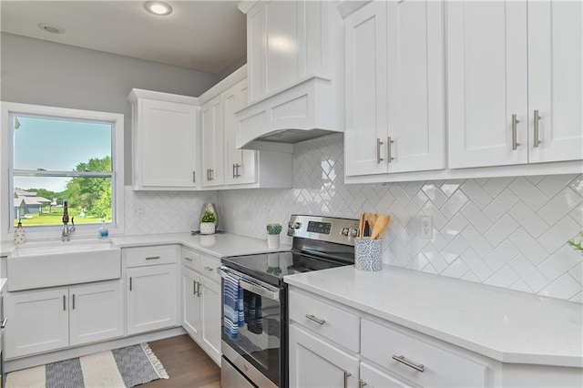 kitchen featuring sink, backsplash, electric range, white cabinets, and custom exhaust hood