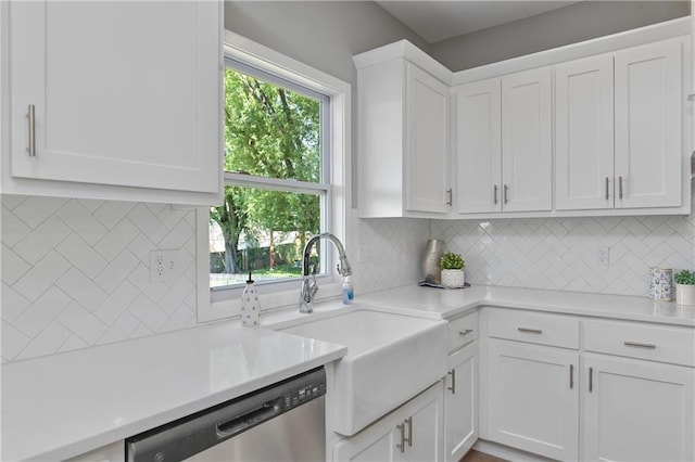 kitchen with stainless steel dishwasher, white cabinets, and backsplash