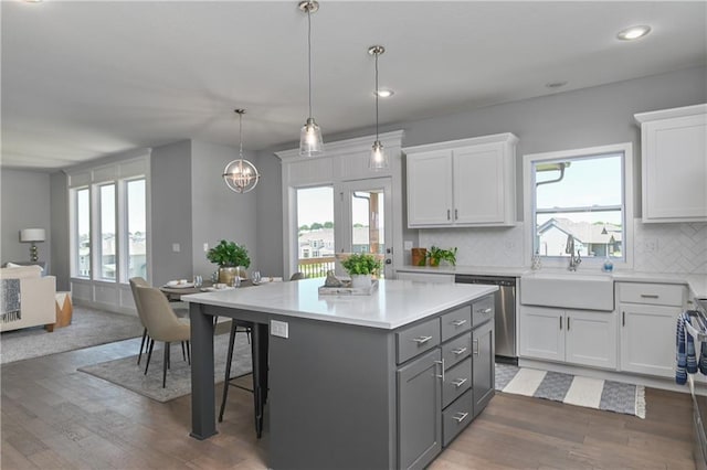 kitchen featuring sink, decorative light fixtures, a kitchen island, stainless steel appliances, and white cabinets