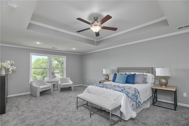 carpeted bedroom with ceiling fan, ornamental molding, and a tray ceiling