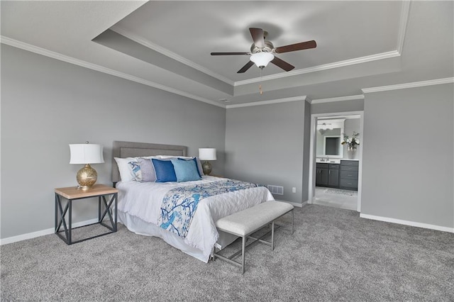 bedroom with a raised ceiling, ornamental molding, carpet floors, and ensuite bathroom