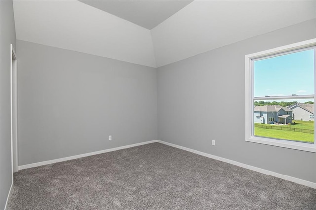 carpeted spare room with vaulted ceiling