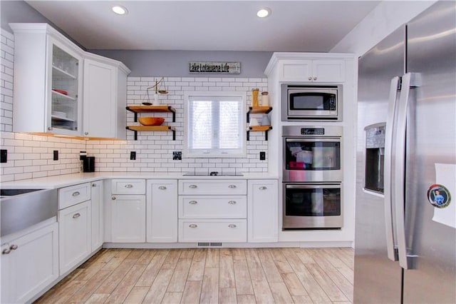 kitchen with appliances with stainless steel finishes, light countertops, white cabinetry, and open shelves