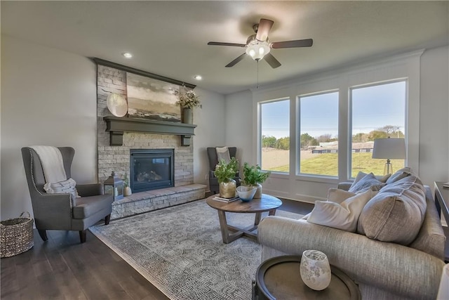 living room with ceiling fan, a fireplace, and dark hardwood / wood-style flooring