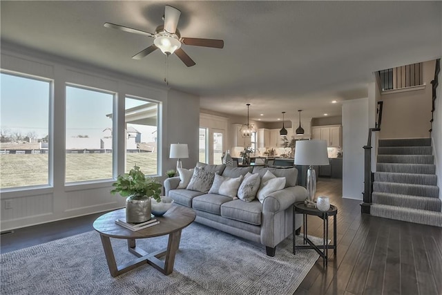 living room featuring ceiling fan and dark hardwood / wood-style floors