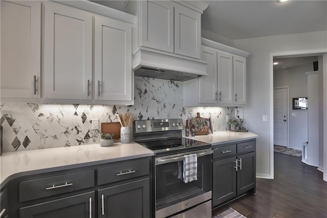 kitchen featuring custom exhaust hood, stainless steel electric range oven, backsplash, and white cabinetry