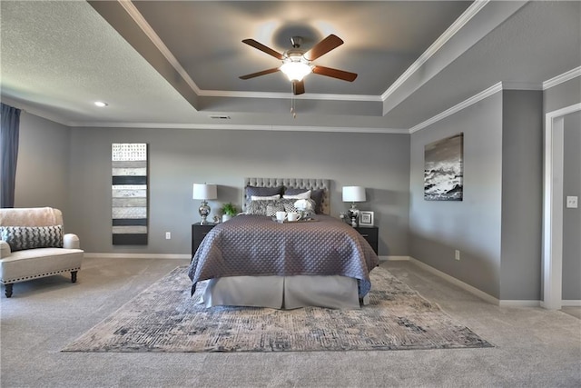 carpeted bedroom featuring ornamental molding, ceiling fan, a textured ceiling, and a tray ceiling