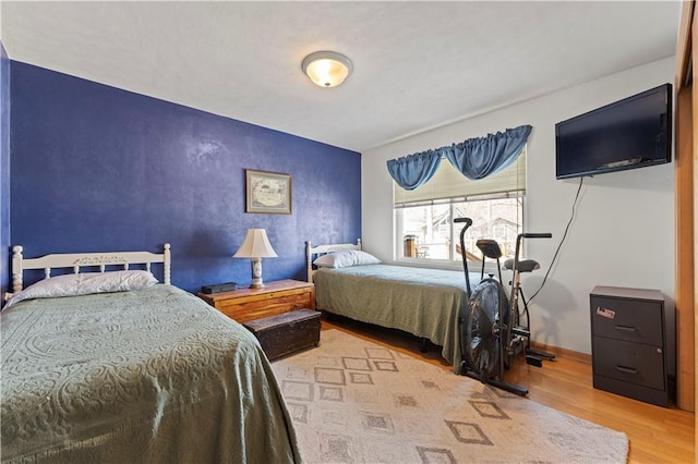 bedroom with light wood-style flooring and baseboards