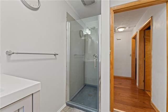 bathroom featuring visible vents, a stall shower, vanity, wood finished floors, and baseboards