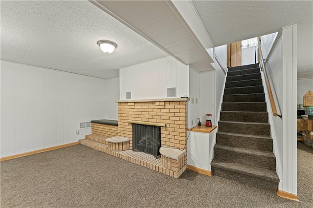 interior space with stairs, a textured ceiling, carpet, and a brick fireplace