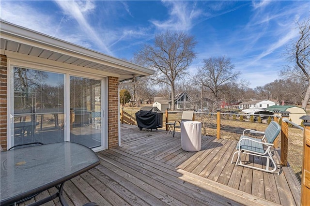 deck with outdoor dining space, area for grilling, and a residential view