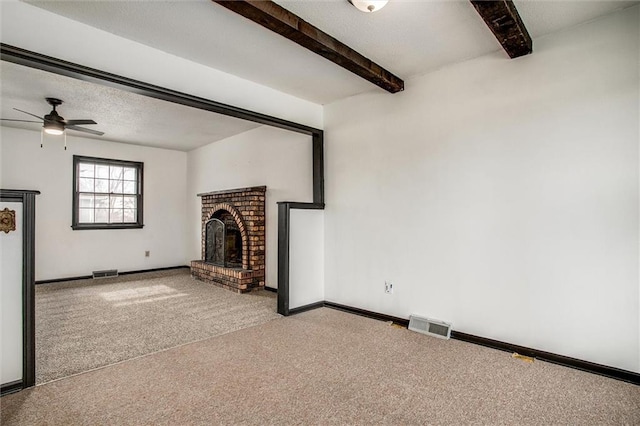 unfurnished living room featuring ceiling fan, a fireplace, beam ceiling, and carpet