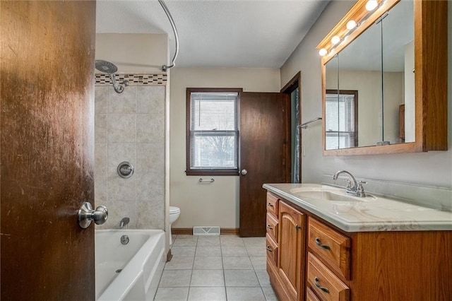 full bathroom with tile patterned flooring, vanity, tiled shower / bath combo, and toilet