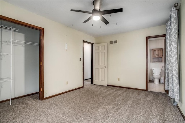 unfurnished bedroom with ensuite bathroom, light colored carpet, ceiling fan, and a closet