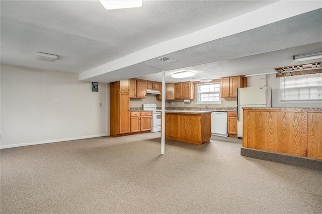 kitchen featuring white appliances, a kitchen island, and a textured ceiling