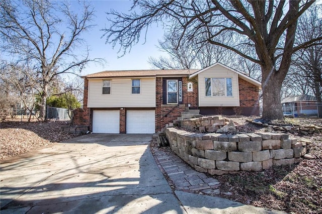 view of front of property with a garage, brick siding, driveway, and fence