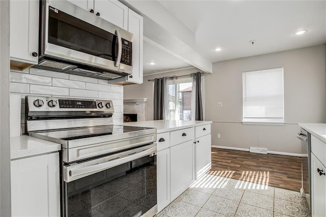 kitchen featuring light countertops, white cabinets, backsplash, and stainless steel appliances