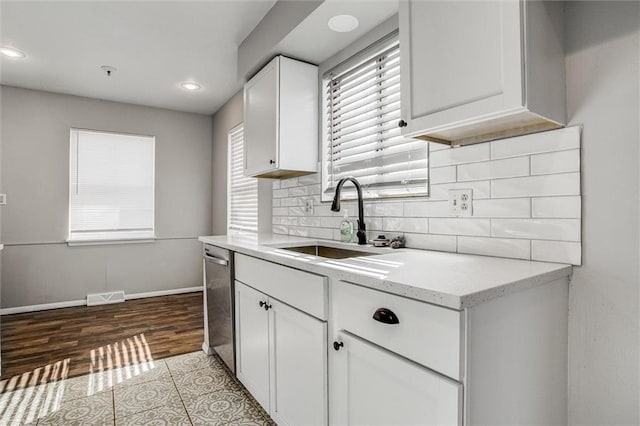 kitchen featuring visible vents, white cabinets, stainless steel dishwasher, and a sink