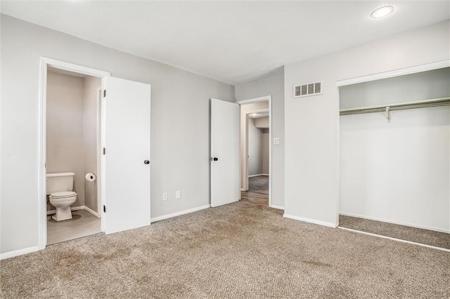 unfurnished bedroom with visible vents, ensuite bathroom, a closet, carpet flooring, and baseboards