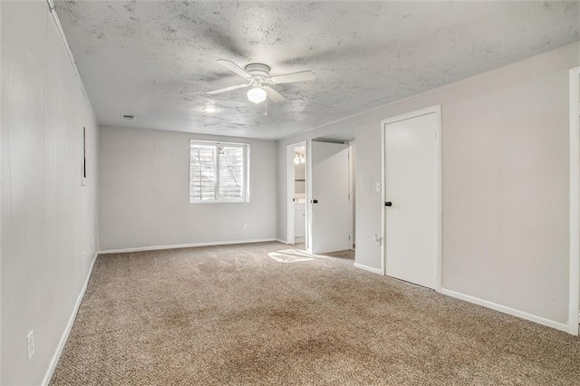 empty room with visible vents, light colored carpet, baseboards, and a textured ceiling