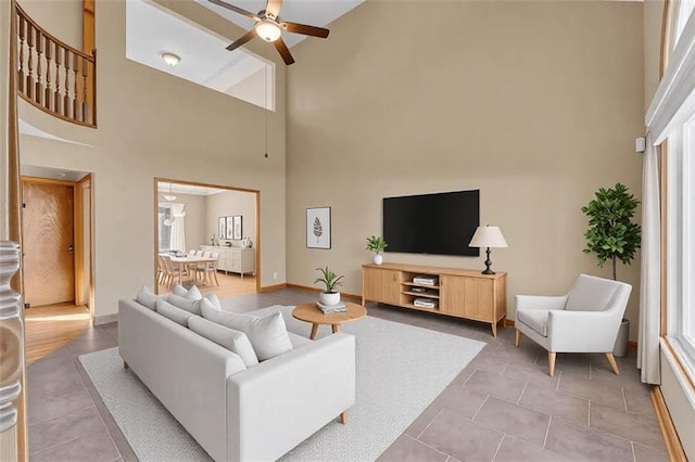 living room with light tile patterned floors, a towering ceiling, and ceiling fan