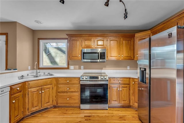 kitchen featuring sink, light wood-type flooring, and appliances with stainless steel finishes