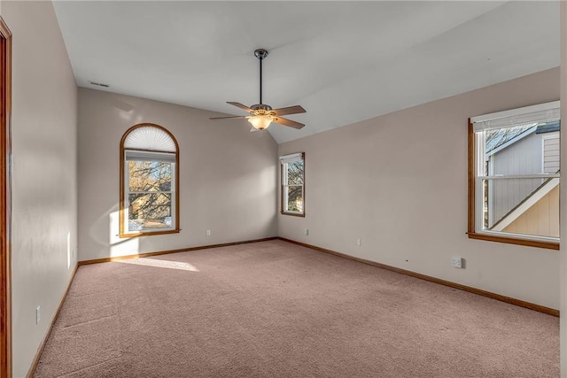 carpeted spare room with ceiling fan and vaulted ceiling