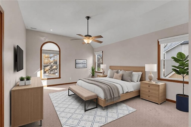 bedroom featuring light colored carpet, vaulted ceiling, and multiple windows